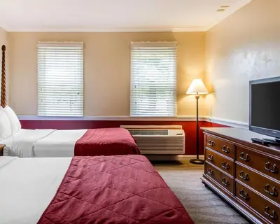 a bedroom with two beds and a flat screen tv at Clarion Inn Strasburg - Lancaster in Strasburg