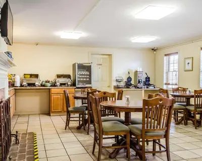 a restaurant with a table and chairs and a kitchen at Clarion Inn Strasburg - Lancaster in Strasburg