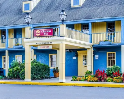 a blue building with a sign for a hotel at Clarion Inn Strasburg - Lancaster in Strasburg
