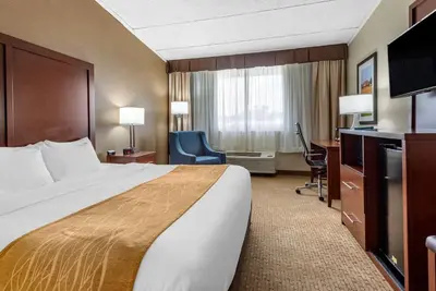 a hotel room with a large bed and a desk at Comfort Inn Lancaster County North in Denver