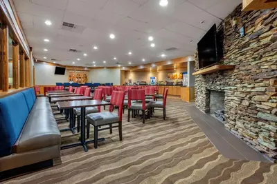 a restaurant with tables and chairs and a stone fireplace at Comfort Inn Lancaster County North in Denver