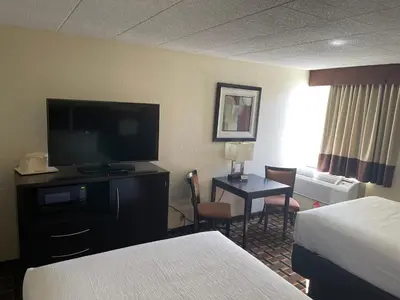 a hotel room with two beds and a flat screen tv at Comfort Inn Dunmore - Scranton East in Dunmore