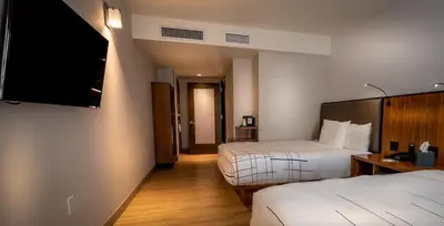 a hotel room with two beds and a flat screen tv at La Quinta by Wyndham Time Square South in New York