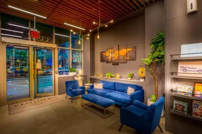 a waiting room with blue couches and chairs at La Quinta by Wyndham Time Square South in New York