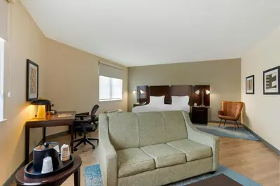 a hotel room with a bed and a couch and a desk at The Prussia Hotel in King of Prussia