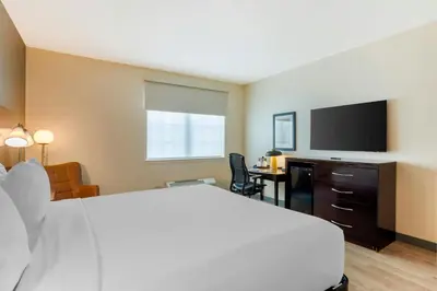 a hotel room with a bed and a flat screen tv at The Prussia Hotel in King of Prussia