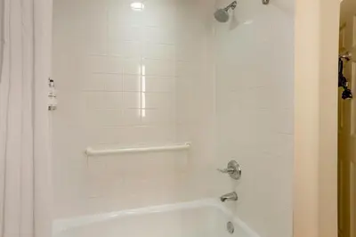 a white bathroom with a tub and a shower at The Prussia Hotel in King of Prussia