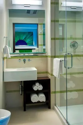 a bathroom with a sink and a mirror and a shower at SpringHill Suites by Marriott New York Midtown Manhattan/Fifth Avenue in New York