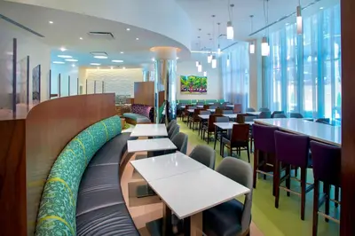 a restaurant with tables and chairs and windows at SpringHill Suites by Marriott New York Midtown Manhattan/Fifth Avenue in New York