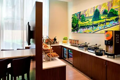 a restaurant with a counter with food on it at SpringHill Suites by Marriott New York Midtown Manhattan/Fifth Avenue in New York
