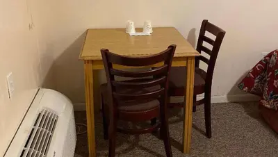 a wooden table with two chairs next to a room at Country Place Inn and Suites White Haven in White Haven