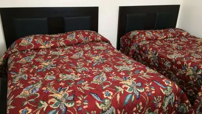 two beds in a room with a red comforter at Country Place Inn and Suites White Haven in White Haven