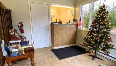 a living room with a christmas tree in a room at Country Place Inn and Suites White Haven in White Haven