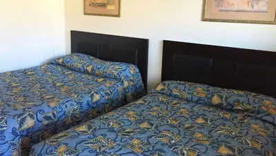 two beds sitting next to each other in a bedroom at Country Place Inn and Suites White Haven in White Haven