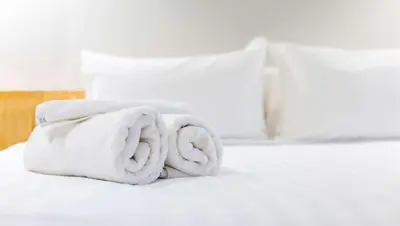 a pile of towels sitting on top of a bed at Country Place Inn and Suites White Haven in White Haven