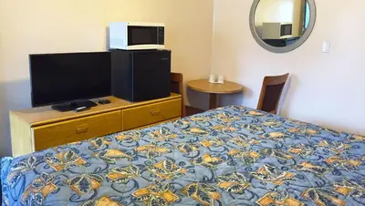 a bedroom with a bed and a tv on a dresser at Country Place Inn and Suites White Haven in White Haven