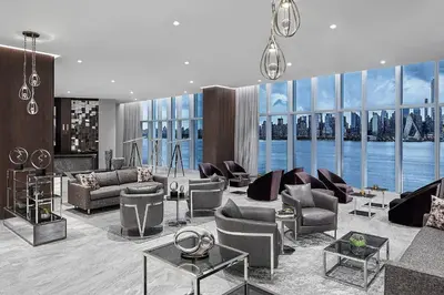 a living room with furniture and a large window at Envue, Autograph Collection in Weehawken