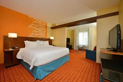 a hotel room with a bed and a flat screen tv at Fairfield Inn & Suites by Marriott Elmira Corning in Horseheads