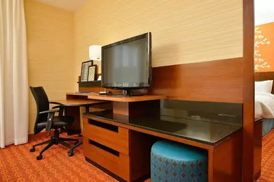 a hotel room with a desk with a television at Fairfield Inn & Suites by Marriott Elmira Corning in Horseheads