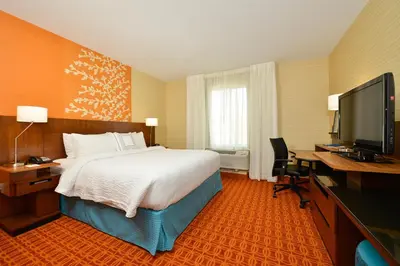 a hotel room with a bed and a desk and a television at Fairfield Inn & Suites by Marriott Elmira Corning in Horseheads