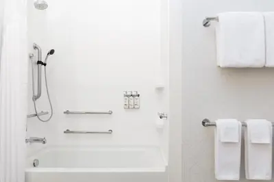 a white bathroom with a shower and a tub and towels at Holiday Inn Express and Suites Limerick - Pottstown by IHG in Limerick