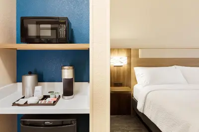 a hotel room with a bed and a microwave at Holiday Inn Express and Suites Limerick - Pottstown by IHG in Limerick