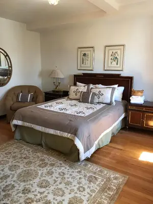 a bedroom with a large bed and a chair at The Castle at Skylands Manor in Ringwood