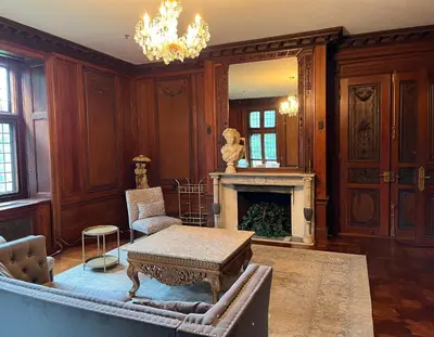 a living room with a table and a fireplace at The Castle at Skylands Manor in Ringwood