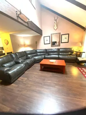 a living room with a leather couch and a coffee table at 106 Village at Camelback in Tannersville