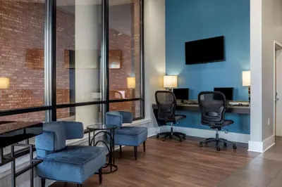 a waiting room with chairs and a desk and a tv at Best Western Plus Philadelphia Airport South - at Widener University in Chester