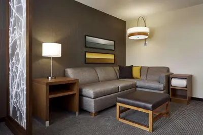 a living room with a couch and a table at Hyatt Place Wilmington Riverfront in Wilmington