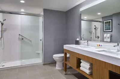 a bathroom with a shower and a sink and a toilet at Hyatt Place Wilmington Riverfront in Wilmington