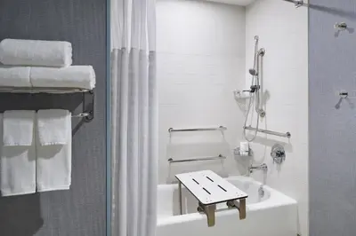 a white bathroom with a sink and a bath tub at Hyatt Place Wilmington Riverfront in Wilmington
