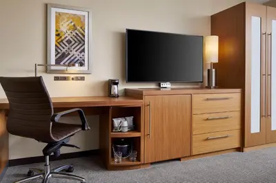 a hotel room with a desk with a television and a chair at Hyatt Place Wilmington Riverfront in Wilmington
