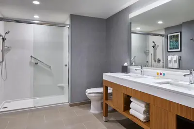 a bathroom with a shower and a sink and a toilet at Hyatt Place Wilmington Riverfront in Wilmington