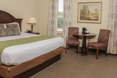 a hotel room with a bed and a table and chairs at The Conwell Inn in Philadelphia