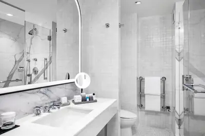 a white bathroom with a sink and a toilet at The Luxury Collection Hotel Manhattan Midtown in New York