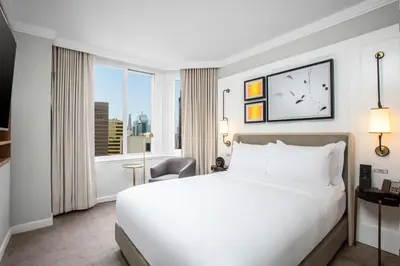 a hotel room with a bed and a large window at The Luxury Collection Hotel Manhattan Midtown in New York
