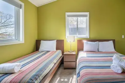 two beds in a room with green walls and windows at Cobalt in Lake Harmony