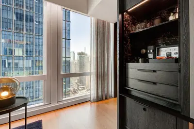 a living room with a large window with a view at Equinox Hotel New York in New York