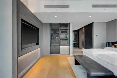 a bedroom with a flat screen tv and a bed at Equinox Hotel New York in New York