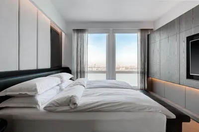 a bedroom with a large bed with a large window at Equinox Hotel New York in New York