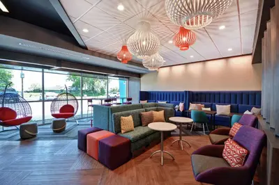 a lobby with a couch and chairs and tables at Tru By Hilton Denver, PA in Denver