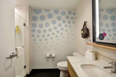 a bathroom with a toilet and a sink and a mirror at Tru By Hilton Denver, PA in Denver