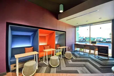 a waiting room with tables and chairs and a window at Tru By Hilton Denver, PA in Denver