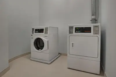 two washing machines and a dryer in a room at Aloft Secaucus Meadowlands in Secaucus