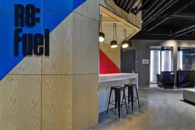 a bar in the middle of a room with stools at Aloft Secaucus Meadowlands in Secaucus