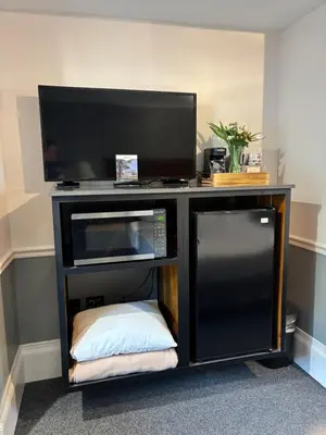 a black entertainment center with a tv and a microwave at SHERWOOD MOTEL in Wellsboro