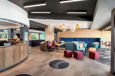 a lobby with a waiting area with colorful chairs and tables at Tru By Hilton Hershey Chocolate Avenue in Hershey