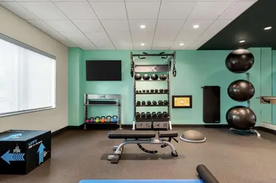 a room with a gym with a bench and weights at Tru By Hilton Hershey Chocolate Avenue in Hershey